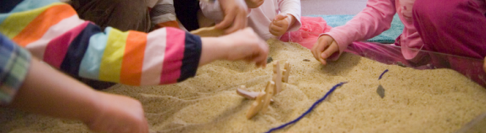 children's hands in sand