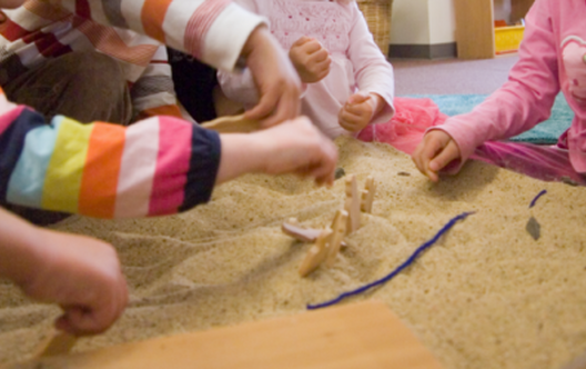 childrens hands in sand